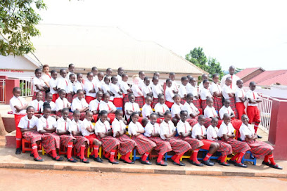 Pupils of Precious Gift Nursery & Primary School in their red-and-white uniforms outside the school